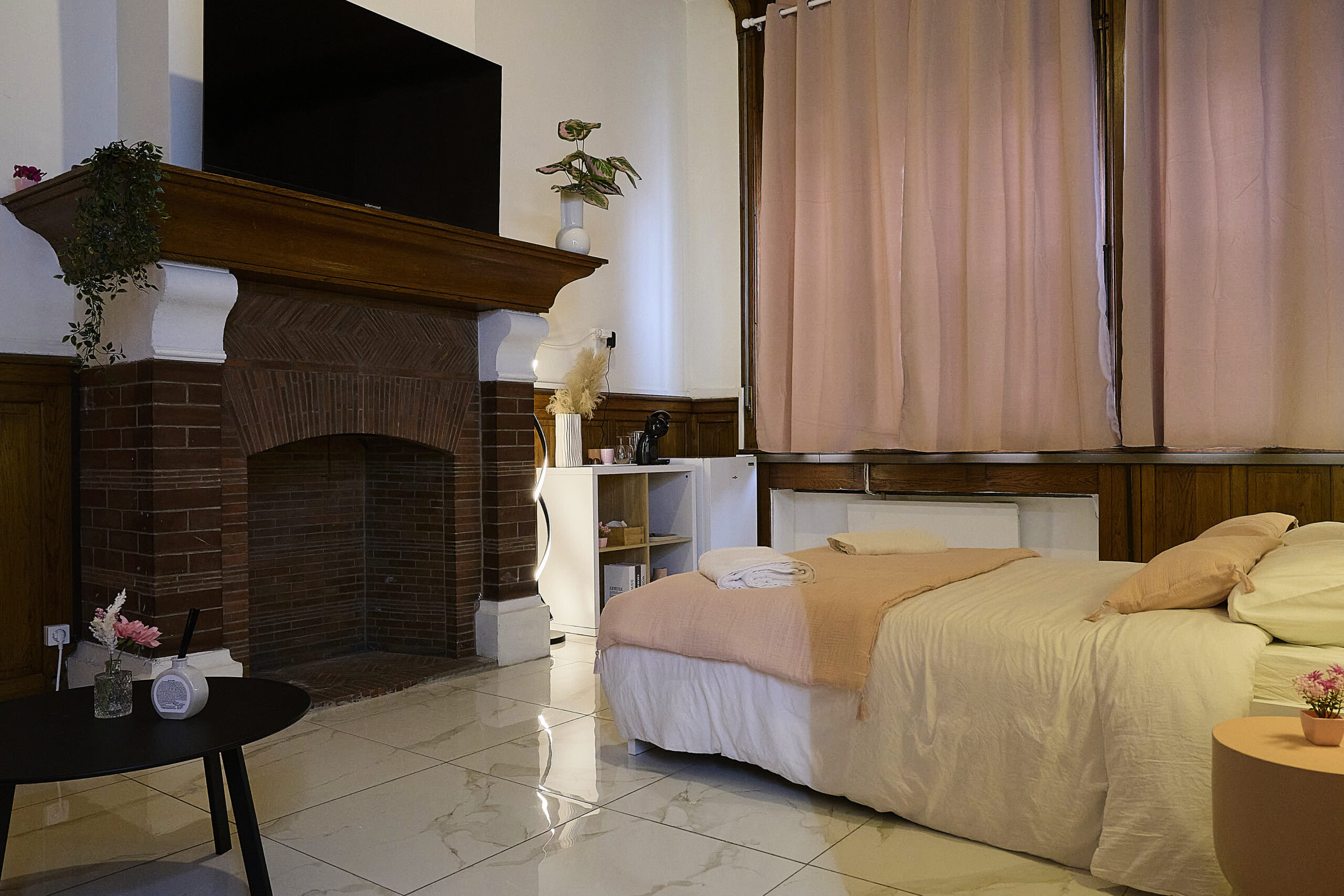 Chambre de la Suite Rose avec cheminée et lit double à Tourcoing