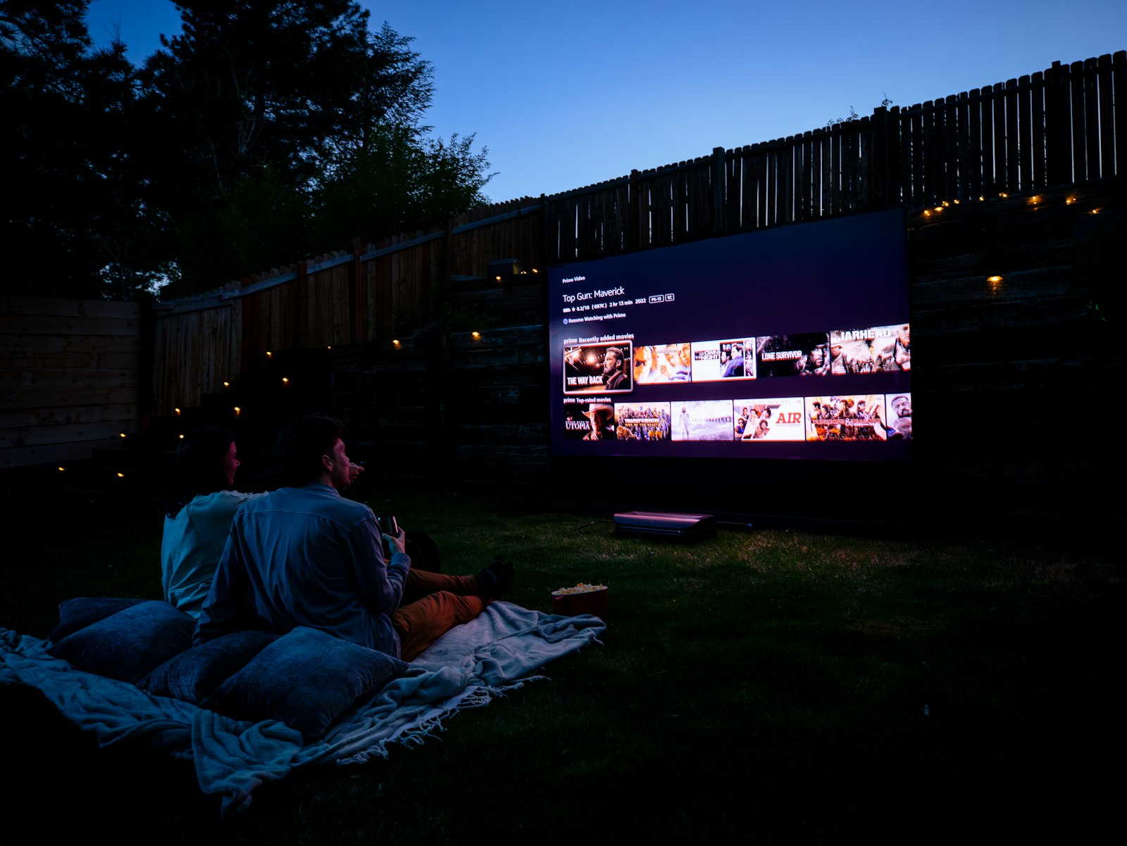 Couple sous une couverture devant un film