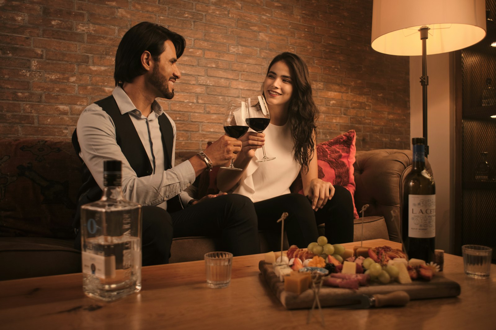 Couple sur un canapé partageant un verre